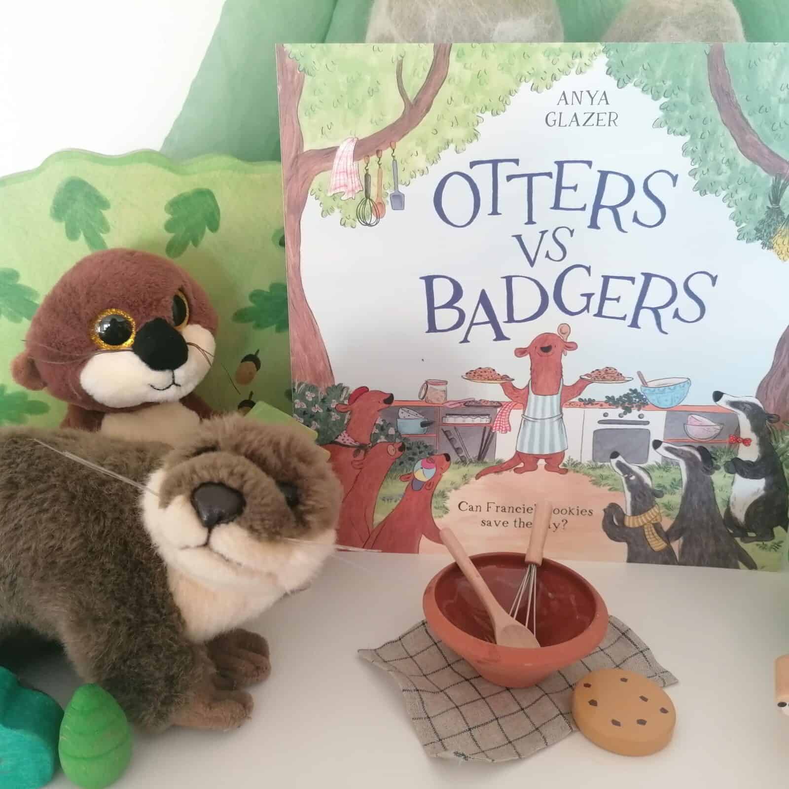 Otters Vs Badgers book with two toy otters and a mini mixing bowl, spoon and whisk