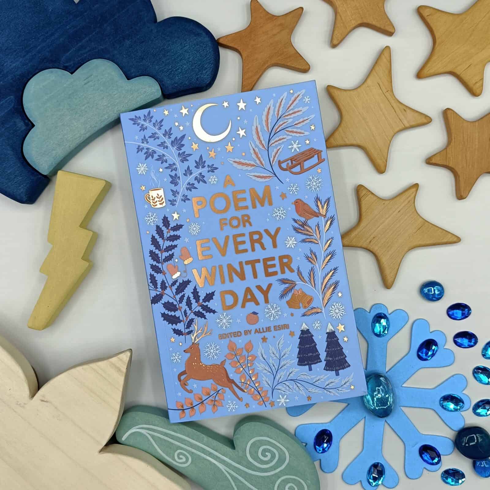 A Poem for Every Day of Winter book placed cover up with wooden weather toys and stars surrounding